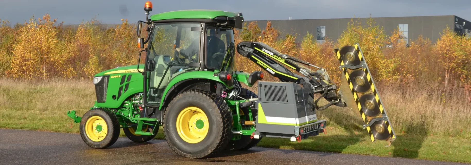 Boom mower in transport position on small tractor