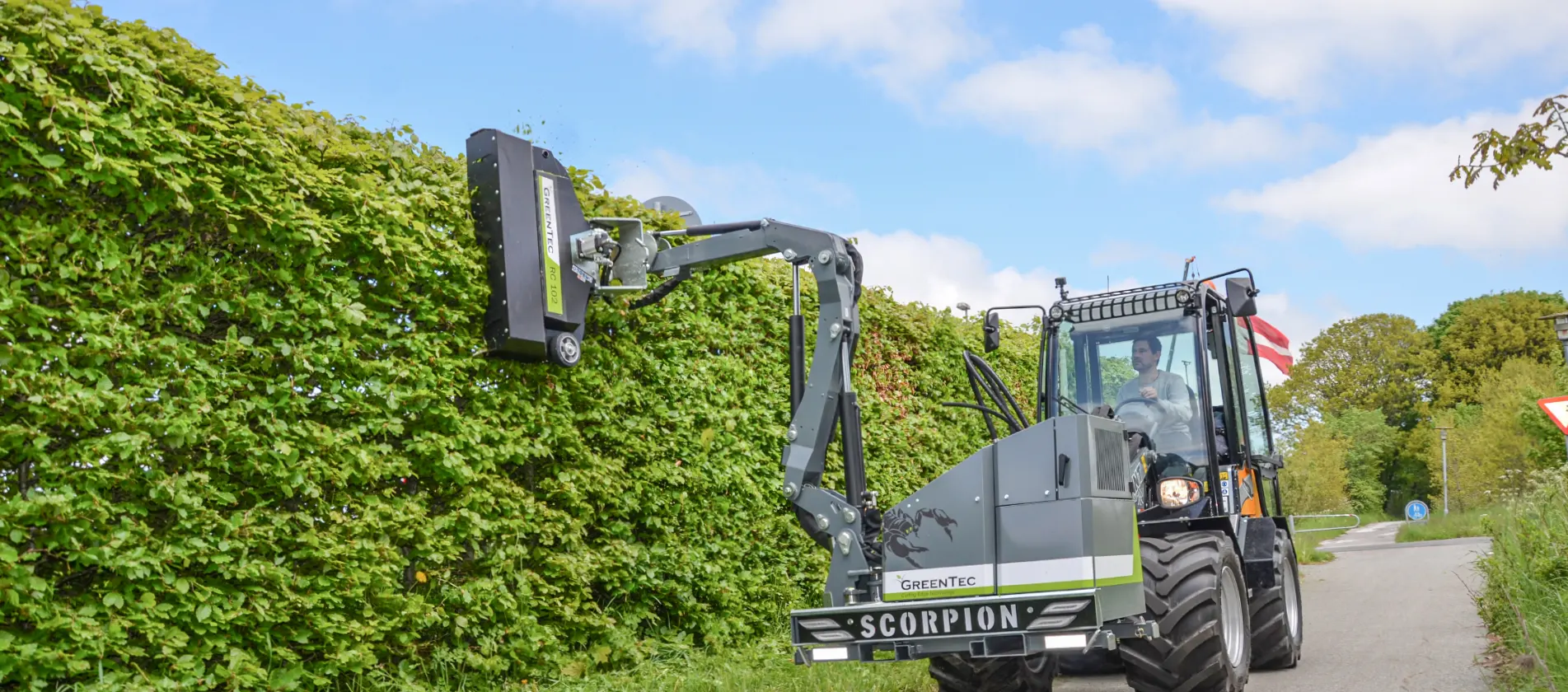 Hedge cutting equipment mounted on skid steer loader
