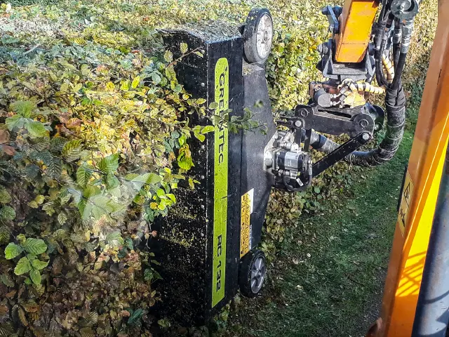 Hydraulic hedge trimmer attached to boom mower arm