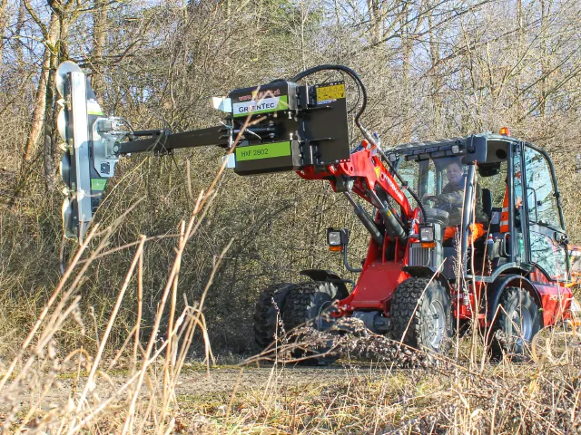 Hydraulic tree trimmer mounted on skid steer loader