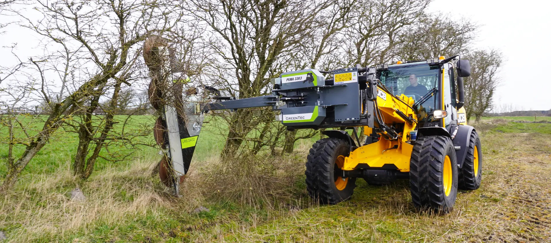 Tree trimming with telehandler on a field
